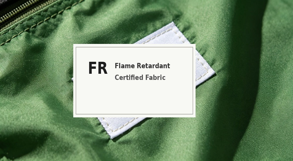 Close-up product shot of flame retardant certification label attached to blue tent tarpaulin material roll, FR rating tag and compliance certificate visible showing fire safety certification for emergency shelter fabric