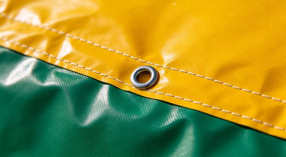 Closeup detail of heavy duty PVC coated polyester fabric texture for humanitarian relief tent, material specification inspection with professional lighting, industrial product photography
