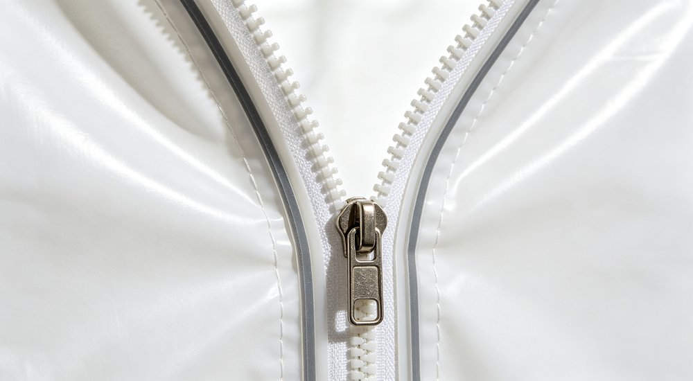 Airtight zipper detail on inflatable isolation tent, close-up of sealed zipper, bright lighting red and white inflatable emergency shelter for disaster relief operations