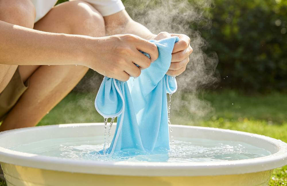 PVA cooling towel soaking in cold basin water activates instantly for long lasting heat relief outdoor workers
