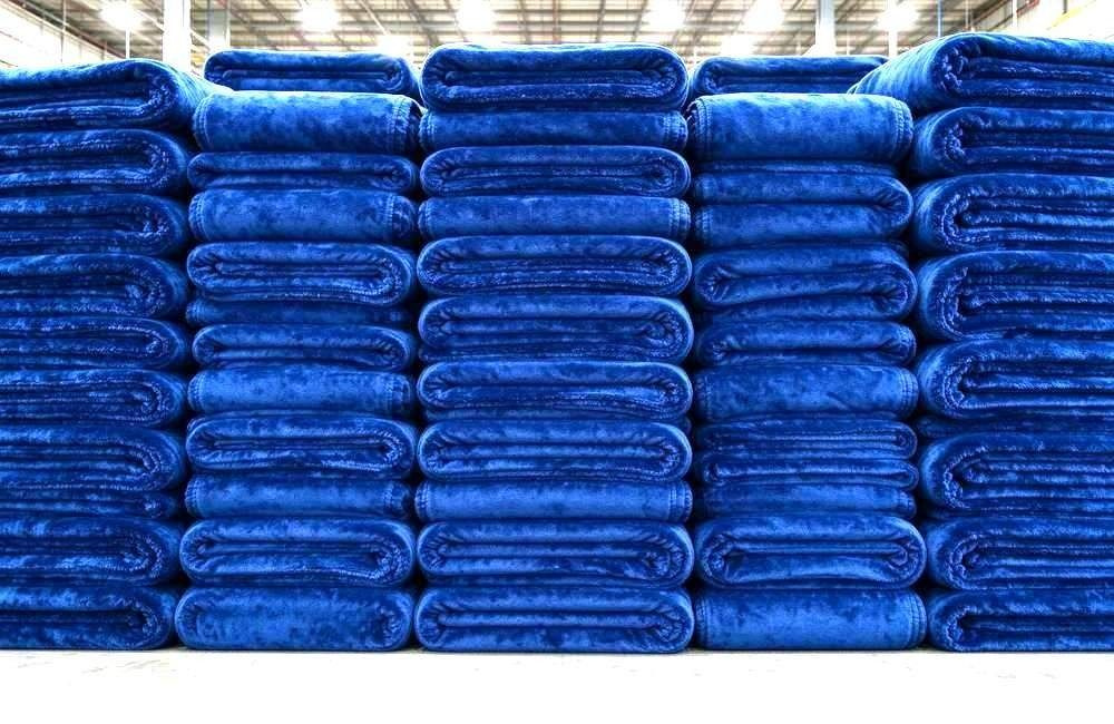 Folded blankets packed into labelled household kits for cyclone response, showing blanket bedding kits per household for distribution and counting