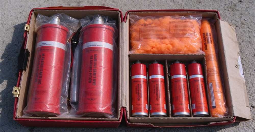 Front view of red marine distress signal flares and parachute rocket set showing SOLAS visual distress signals
